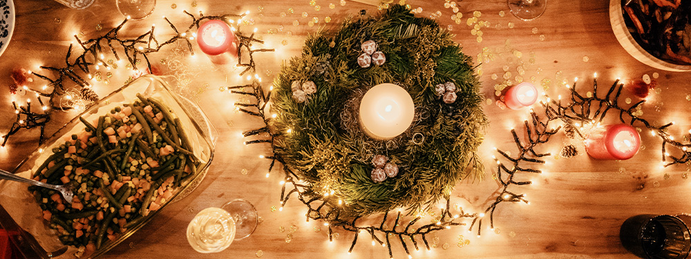 Weihnachtlich geschmückter Esstisch mit Kerzen und Lichterkette