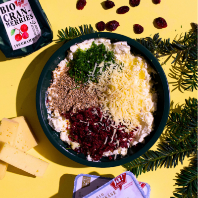 Frischekäse in einer Schale mit Käse, Cranberries und Kräutern