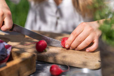Jemand schneidet Bio-Radieschen.