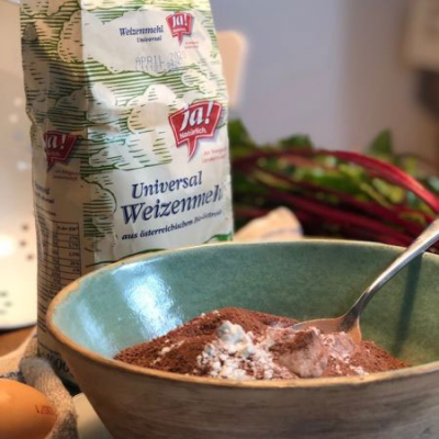 Eine Packung Ja! Natürlich Bio-Weizenmehl und eine Schüssel mit Mehl, gemischt mit Kakao.