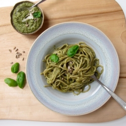 Ein Teller mit Spaghetti und grünem Pesto.