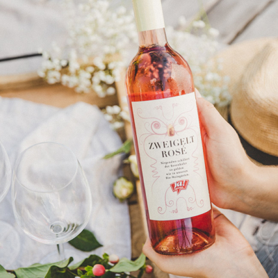 Jemand präsentiert eine Flasche Ja! Natürlich Bio-Zweigelt Rosé.