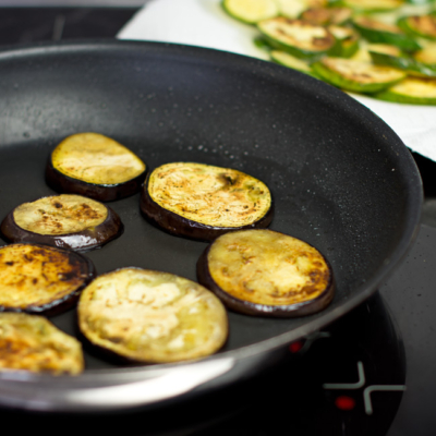 Bio-Melanzanischeiben in einer Pfanne.