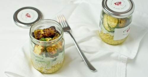 Zwei Gläser mit Ja! Natürlich Bio-Hirsesalat mit gerösteten Melanzani, Zucchini und Gurken-Minzjoghurt.