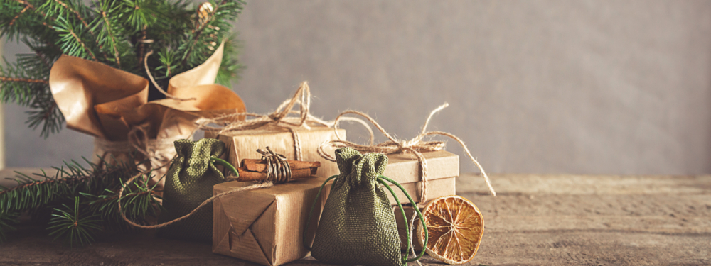 Verpackte Geschenke vor einem Weihnachtsbaum.