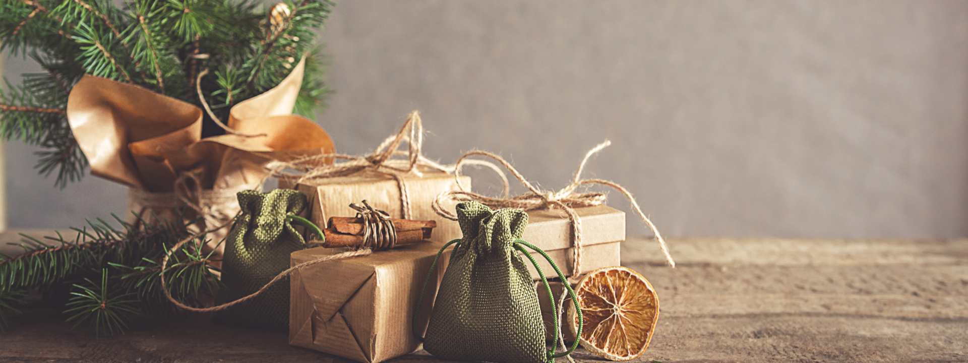 Verpackte Geschenke vor einem Weihnachtsbaum.