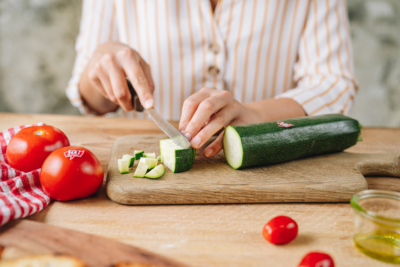 Jemand schneidet Bio-Zucchini.