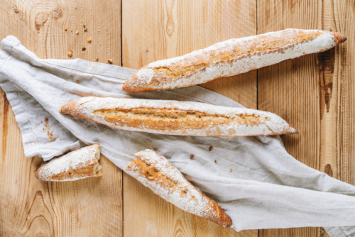 Drei Baguettes auf einem weißen Tuch.