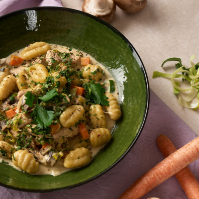 uten-Gnocchi-Pfanne mit Champingnons, Karotten und Lauch auf einem Teller angerichtet