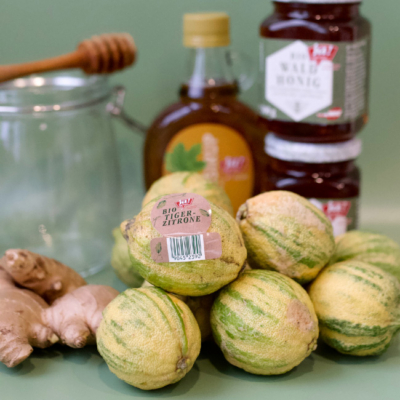 Bio-Tigerzitronen auf einem Tisch mit Honig und Ingwer