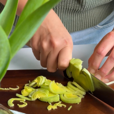 Lauch in wird in feine Ringe geschnitten.