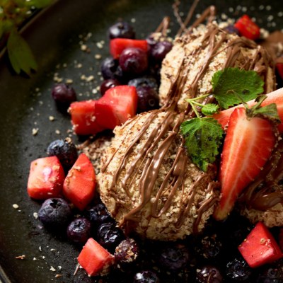 Skyr Beeren Knödel angerichtet mit Bio-Nougatcreme, Bio-Beeren und Bio-Minze.