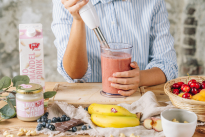 Jemand püriert Bio-Obst von Ja! Natürlich zu einem Smoothie.