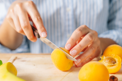 Jemand schneidet Bio-Marillen auf.