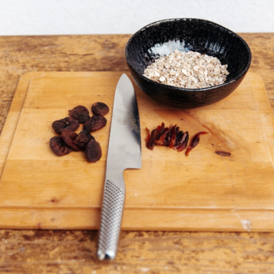 Getrocknete Bio-Marillen werden auf einem Schneidebrett klein geschnitten.