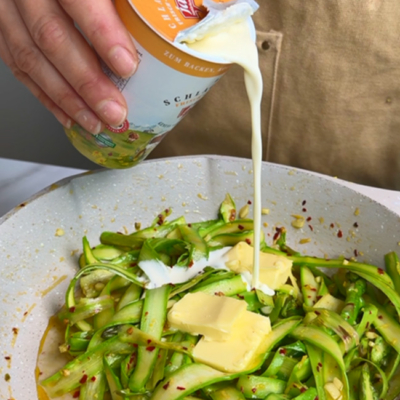 Bio-Spargel, Bio-Zitronensaft, Bio-Butter und Bio-Schlagobers in einer Pfanne köcheln.