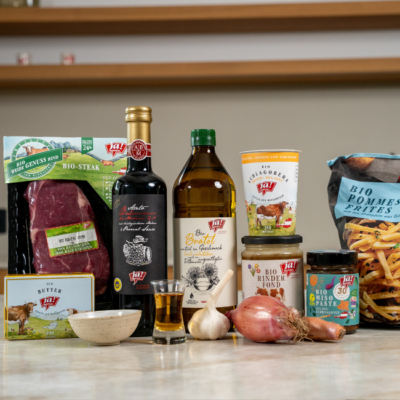 Alle Zutaten für das Bio-Steak mit Pfeffersauce und Bio-Pommes Frites auf einem Tisch nebeneinander aufgestellt.