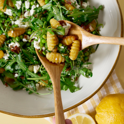 Bio-Gnocchi-Salat in einer Schüssel angerichtet und daneben frische Bio-Zitronen.