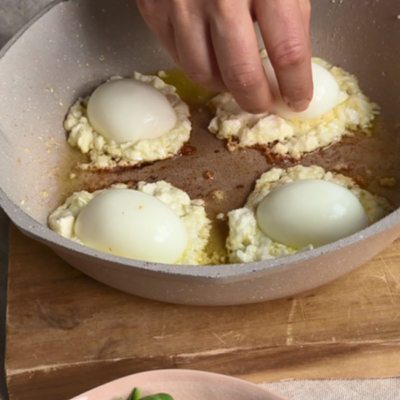 Die halbierten Bio-Eier auf den angebratenen Bio-Feta legen und anbraten.