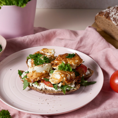 Crispy Feta Eggs auf einem Bio-Brot angerichtet auf einem Teller.