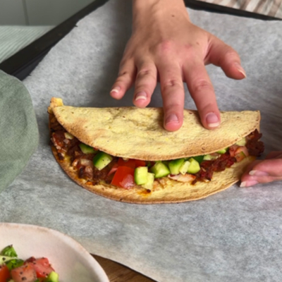 Lahmacun belegt mit frischem Bio-Gemüse wird zugeklappt.