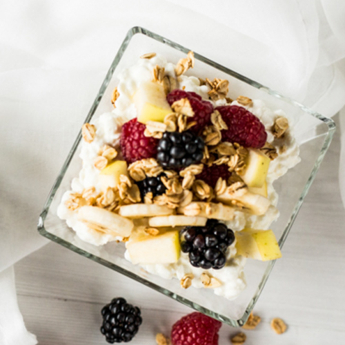 Bio-Cottage Cheese als Frühstück in einer Bowl mit Bio-Früchten und Bio-Nüssen