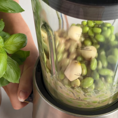 Bio-Zutaten für einen Bio-Edamame-Hummus werden in einem Mixer püriert.