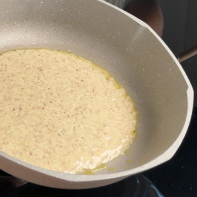 Der Teig für die Leinsamen-Oat Wraps wird in einer Pfanne ausgebacken.