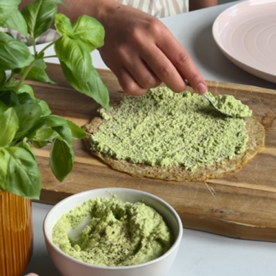 Bio-Edamame-Hummus wird Leinsamen-Oat-Wrap gestrichen.
