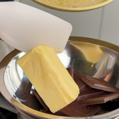 Bio-Butter und Bio-Edelbitterschokolade wird in einer Schüssel geschmolzen.