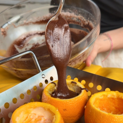 Die ausgehöhlten Bio-Orangen werden mit dem Teig befüllt.