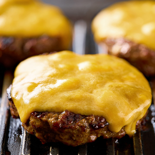 Schmelzender Ja! Natürlich Bio-Käse auf einem saftigen Fleisch-Patty.
