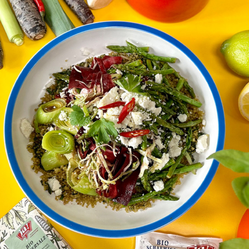 Bunter Bio-Quinoa Salat mit frischem Bio-Spargel und Bio-Rote Rüben serviert in einer Schüssel.