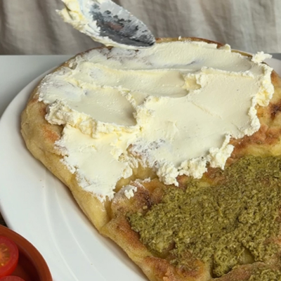 Focaccia mit Bio-Frischkäse und Bio -Genovese Pesto bestreichen.