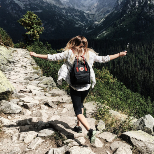 Eine Frau von hinten, die durch die österreichischen Alpen wandert.