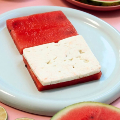 Zwei Scheiben Bio-Wassermelone und eine Scheibe Ja! Natürlich Bio-Feta auf einem Teller.