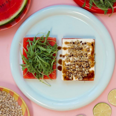 Zwei Hälften des Bio-Wassermelonen-Feta-Sandwich' auf einem Teller liegenden.