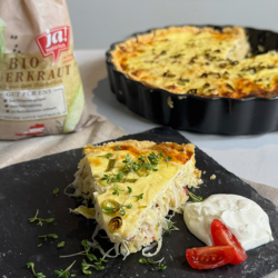 Bio-Sauerkraut Quiche auf einem Steinbrett.