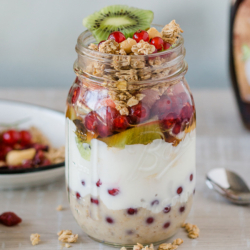 Bio-Joghurt-Bowl mit Bio-Granola, Bio-Obst in einem Glas.