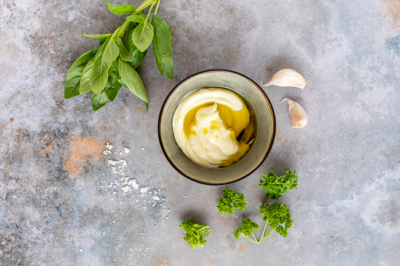 Eine Schüssel mit Bio-Kräuter-Aioli und frischen Kräutern.