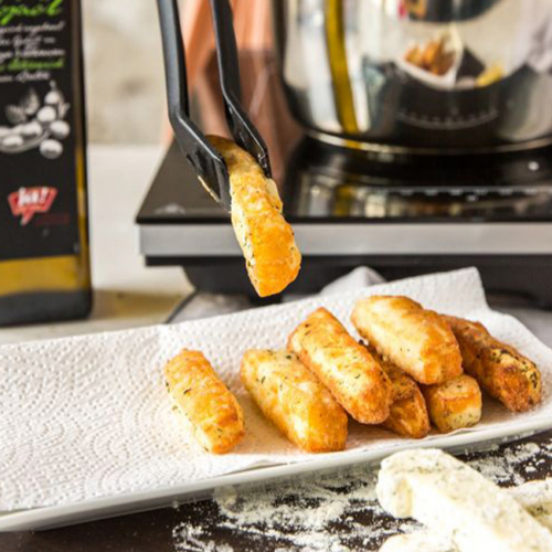 Selbstgemachte Halloumi-Fries werden aus der Fritteuse auf einen Teller gelegt.