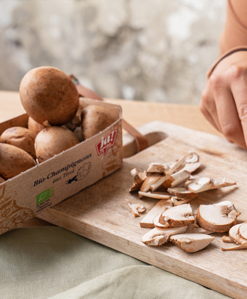 Pilzverpackung und geschnittenen Pilze auf einem Brett