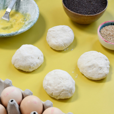 Der Teig für die Protein Bagels liegt geformt zu kleinen Bällchen auf einem Tisch.