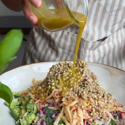 Das Dressing wird über den Brokkoli-Apfel-Salat gegeben und anschließend alles gut durchmischt.
