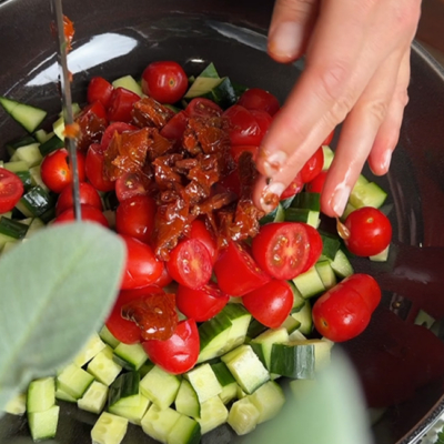 Das geschnittene Bio-Gemüse für den Salat wird in eine Schüssel gegeben.