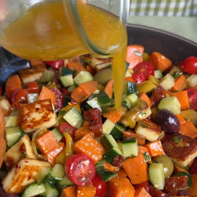 Über den Süßkarotffel-Halloumi Salat wird das Dressing gegeben und alles gut vermengt.
