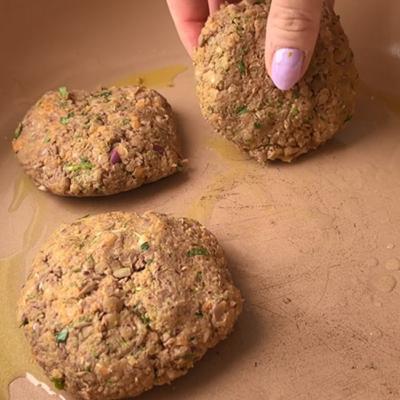 Die selbstgemachten Linsenpatties werden in einer Pfanne goldbraun angebraten.