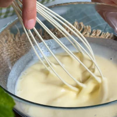 Bio-Ei, Bio-Joghurt griechischer Art, Bio-Olivenöl und Wasser werden in einer Schüssel verrührt.