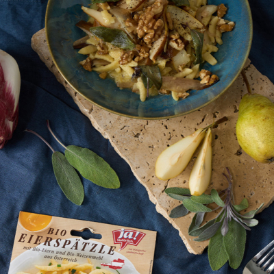 Spätzle mit frischen Bio-Salbeiblättern und Bio-Walnüssen getoppt, in einer Schüssel serviert.