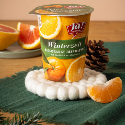 Winterzeitjoghurt Mandarine-Orange auf einem Tisch drapiert